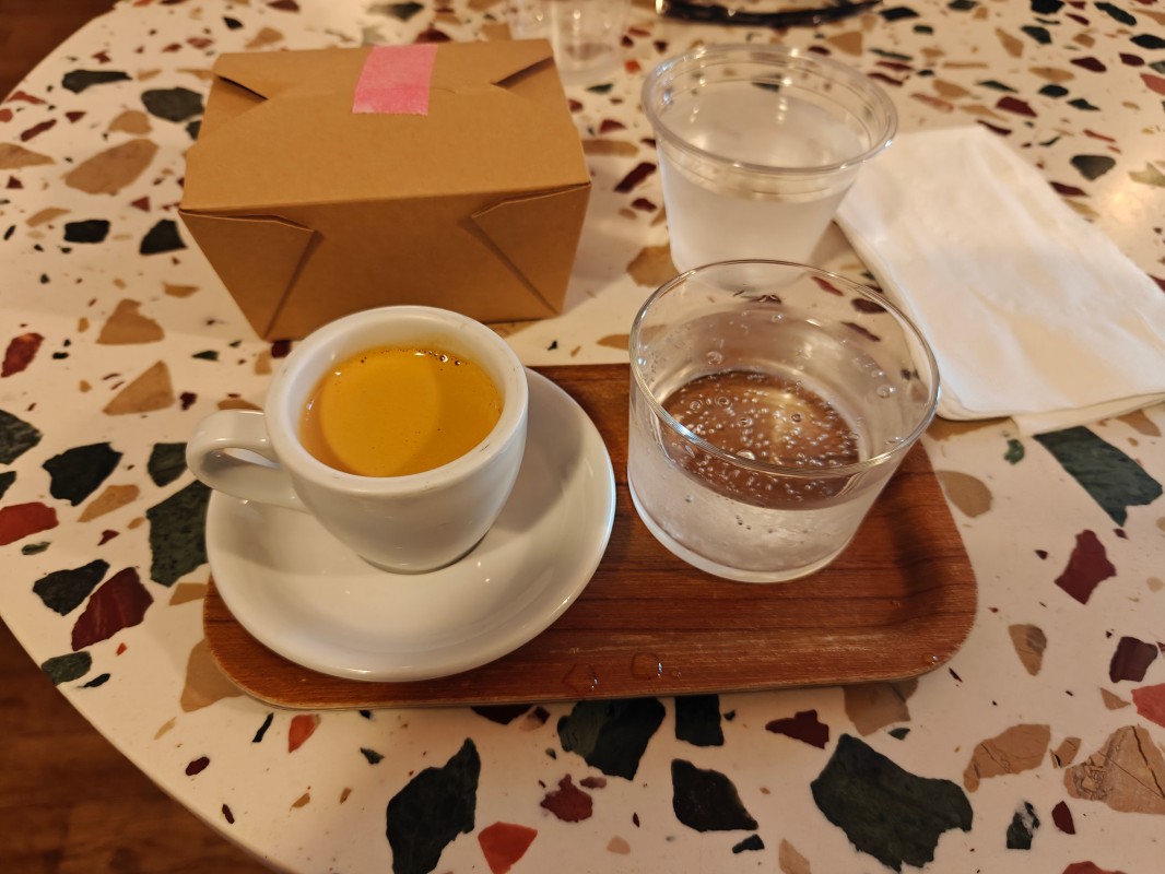 A picture of an espresso with a glass of water